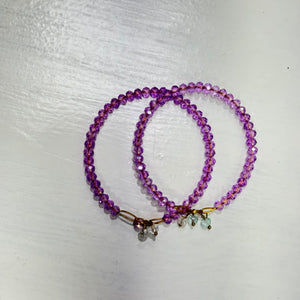 Pink beaded bangles with colorful tassels and gold-tone chain details