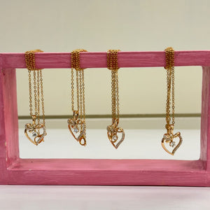 Gold-tone heart pendant necklaces with delicate chains and sparkling details