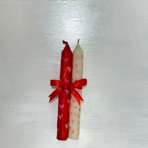Handcrafted red and ivory taper candle set decorated with hearts, patterns and red ribbon bow