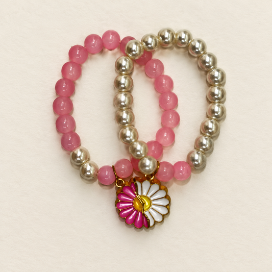 Double Pearls Bracelet close-up showing pink and silver-tone beads and the floral charm, AI-assisted image